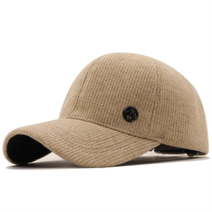 Close-up of beige knit corduroy baseball cap texture with M logo detail