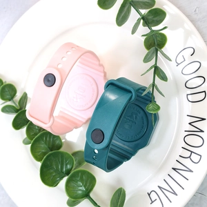 Detail of pink and green LED watches on a white plate with CE and RoHS certifications