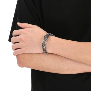 Close-up of retro silver dragon head charm on braided leather bracelet for men