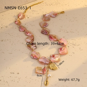 Detail view of pink shell bead necklace with gold conch charms and pearl accents