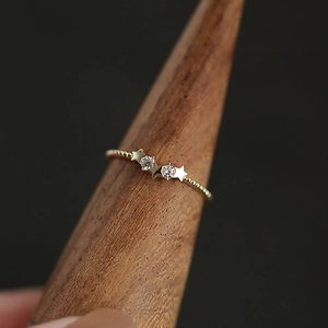 Macro shot of 14k gold plated sterling silver star ring with zircons on wooden stand