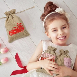 Detailed view of linen drawstring gift bags with heart prints and festive motifs