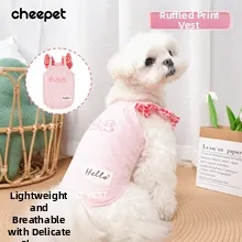 Close-up of pink pet vest featuring ruffled sleeves and a cartoon puppy print pattern