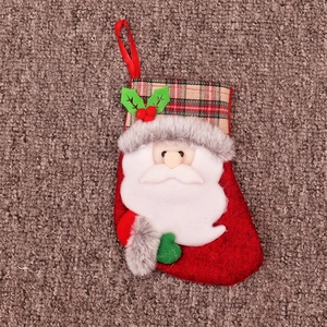 Détail d'une chaussette de Noël rouge avec appliqué Père Noël et revers à carreaux
