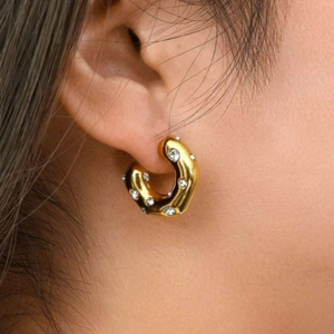 Hammered C-shape gold earrings with zircons shown on model for a trendy look
