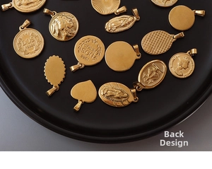 Makroansicht von Vintage 18K vergoldeten Herz- und Münzanhängern mit Porträt