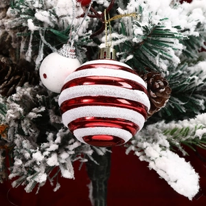 Close-up of red and white striped Christmas ornaments with glitter on snowy pine tree branches
