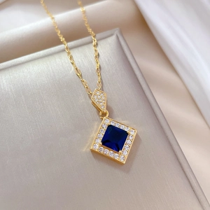 Detailed macro of gold necklace with blue rhombic gemstone pendant and micro-pave diamonds