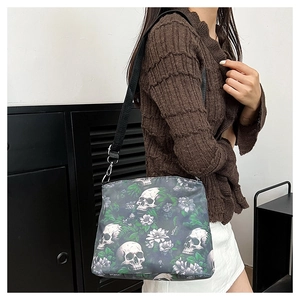 Detail of crossbody bag with skull and purple floral print on model in indoor setting