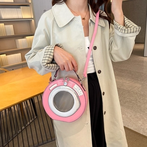 Unique pink washing machine shaped handbag with top handle and shoulder strap shown on model