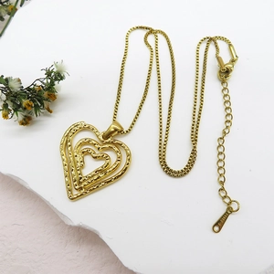 Detail of 18K gold plated stainless steel necklace with triple hollow heart pendants