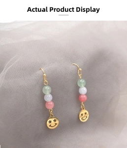 Detailed close-up of Chinese style clown mask earrings with colored jade beads and gold hooks