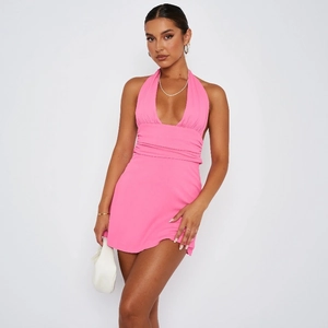 Detail of hot pink halter neck mini dress featuring deep V-neck and pleated waist details