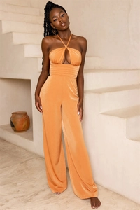 Detail of orange satin halter jumpsuit showing cutout bust and pleated high waist design