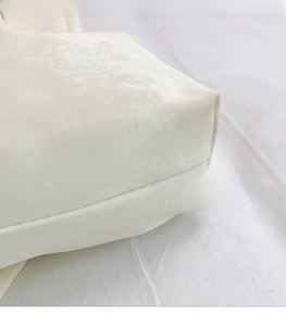 Macro detail of creamy white pleated fabric texture with soft pearlescent sheen for bag