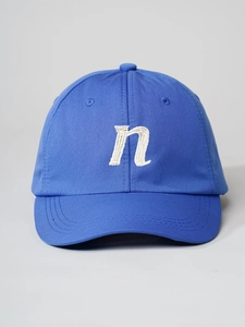 Detailed embroidery of lowercase letter n on royal blue cotton twill baseball cap
