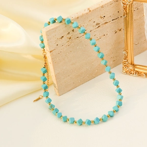 Elegant beaded turquoise necklace with gold accents on a luxury marble and silk background