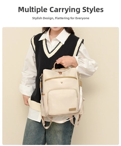 Detail of soft cream nylon backpack with brown leather trim and multi-pocket design