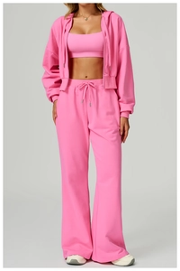 Three-piece pink loungewear set featuring zip-up hoodie, sports bra, and wide-leg sweatpants