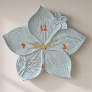 Detail of flower shaped wall clock with blue resin petals and fairy relief texture