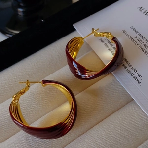 Close-up of vintage red enamel and gold-tone twisted U-shaped hoop earrings in gift box