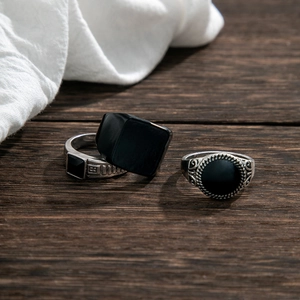Vintage silver and black alloy men's rings set on a rustic wooden texture background