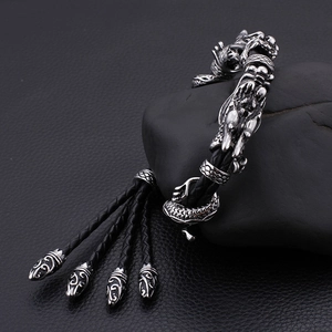 Détail du fermoir tête de dragon argenté sur bracelet en cuir tressé noir
