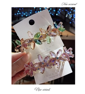 Detailed macro view of colorful crystal flower spring hair clips on display card