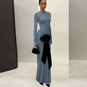 Detail of waist-slimming pleats and large black bow decoration on a mist blue dress