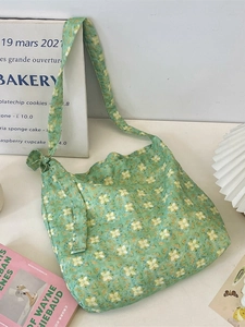 Floral print green tote bag with knotted strap on a clean aesthetic desk setup