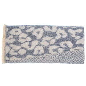 Detailed view of woven leopard print scarf with blue accents and fringe edge texture