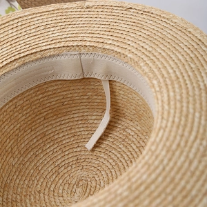 Detailed macro view of the inner sweatband and adjustable drawstring of a straw hat