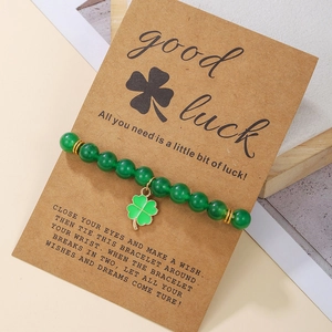 Detail of green beaded clover bracelet on a 'Good Luck' kraft card packaging