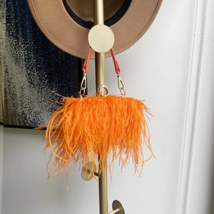 Detail of orange ostrich feather bag with sparkling rhinestone ring clasp and gold hardware