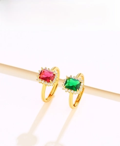Detail of luxury emerald and ruby cut crystal rings with halo diamonds on gold bands