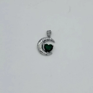 Macro view of crescent moon and green heart zircon pendant in silver finish