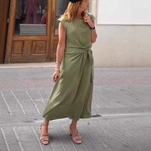 Detail of sage green midi dress featuring elegant waist tie knot and pleated design