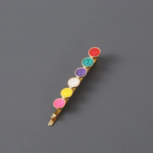 Golden metal hair clip featuring six colorful round enamel heart decorations in a studio view