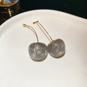 Vue macro de boucles d'oreilles cerises avec paillettes grises et crochets dorés