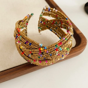 Détail d'un bracelet bohème multicouche en perles de verre sur un plateau en bois