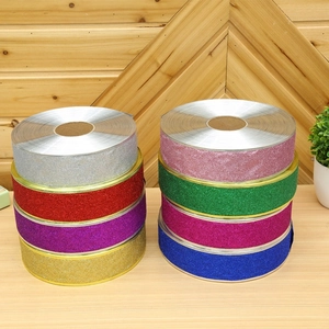Close-up of sparkling glitter ribbon rolls in various colors for Christmas gift wrapping
