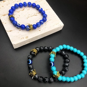 Detail of crown bracelets with turquoise and evil eye beads on stone display