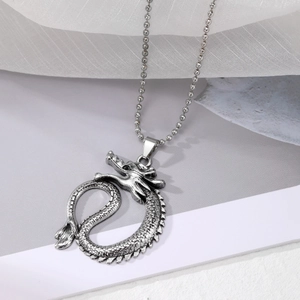 Detail of vintage silver dragon pendant with intricate scales on a matching bead chain
