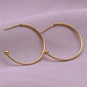 Macro detail of 18K gold plated stainless steel hoop earrings with small metal ball