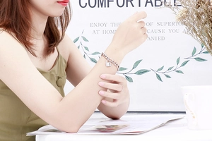 Detailansicht eines silbernen Edelstahl-Schlossarmbands am Handgelenk einer Frau