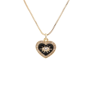 Golden heart necklace with black enamel evil eye and sparkling zircon on white backdrop