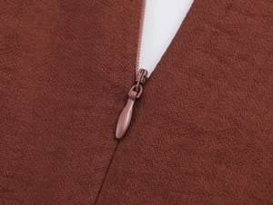 Detail view of the seamless invisible zipper on a textured long sleeve brown dress
