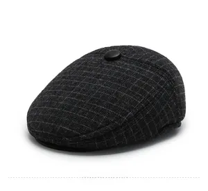 Detailed side view of dark grey plaid flat cap showing thick wool texture and top button