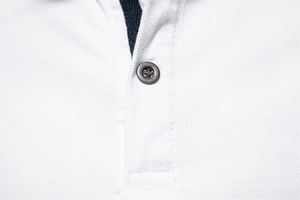 Close-up of white cotton piqué Polo shirt collar and button placket detail