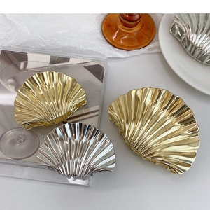 Detailed close-up of scallop hair claw clips in polished gold and silver metallic finishes